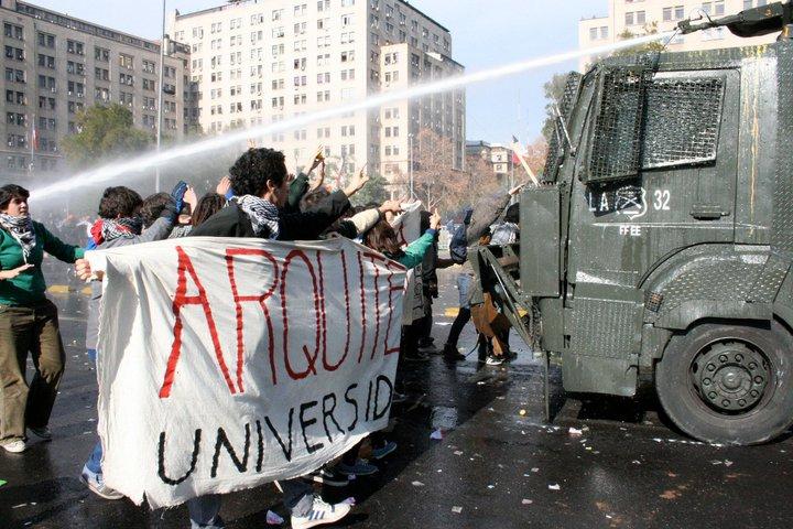 Studierende der Architekturfakultät blockieren einen Wasserwerfer