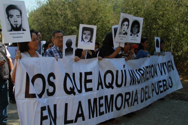 Angehörige mit Bildern von Verschwundenen. Auf dem Transparent: "Die hier starben, leben in der Erinnerung des Volkes"
