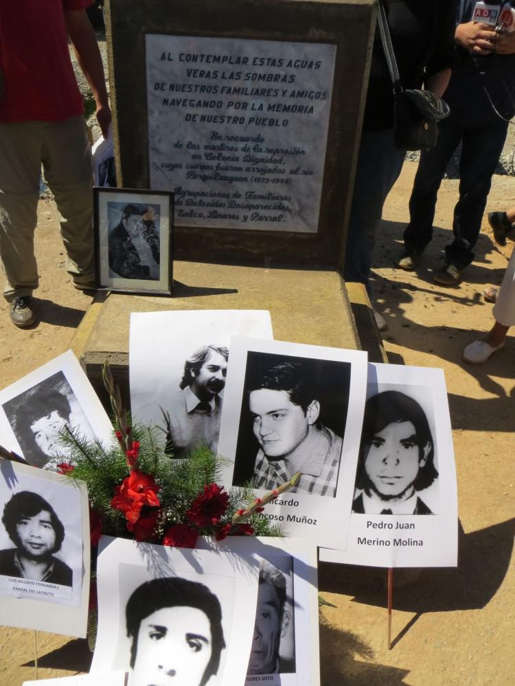 Vor dem Gedenkstein liegen Fotos von Verschwundenen