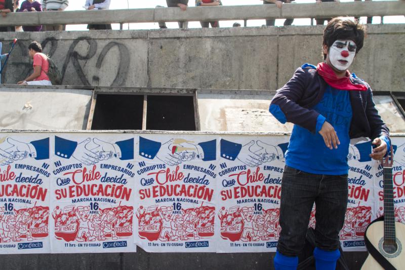 Ein Clown posiert vor dem Plakat mit dem Aufruf zur Demonstration. Darauf steht: "Weder Korrupte noch Unternehmer. Chile soll über seine Bildung entscheiden" Ein Clown posiert vor dem Plakat mit dem Aufruf zur Demonstration. Darauf steht: "Weder Korrupte noch Unternehmer. Chile soll über seine Bildung entscheiden"