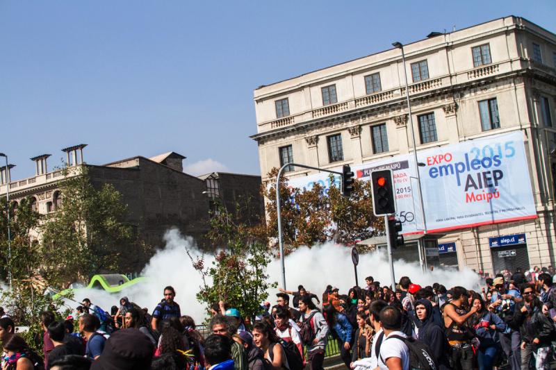 Eine Tränengaswolke steigt hinter Demonstranten auf