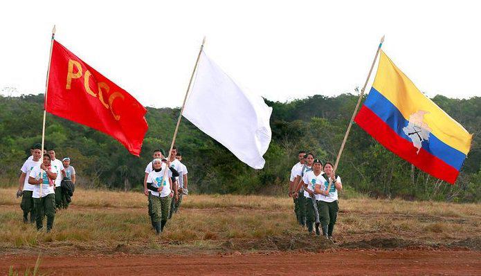 Drei Fahnen bei der 10. Guerillakonferenz: die der verbotenen kommunistischen Partei, die Friedens- und die Farc-Fahne
