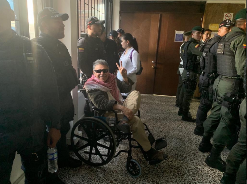 Jesús Santrich im Rollstuhl auf dem Weg zum VErhandlungssaal bewacht von Polizeikräften