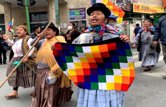 Frauen demonstrieren mit der indigenen Fahne gegen den Rassismus der Putsch-Regierung