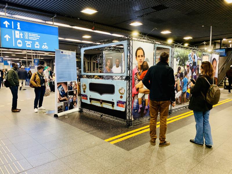 Installation mit Fotos venezolanischer Migranten im größten Bahnhof Belgiens, dem Gare du Midi in Brüssel, anläßlich der Konferenz