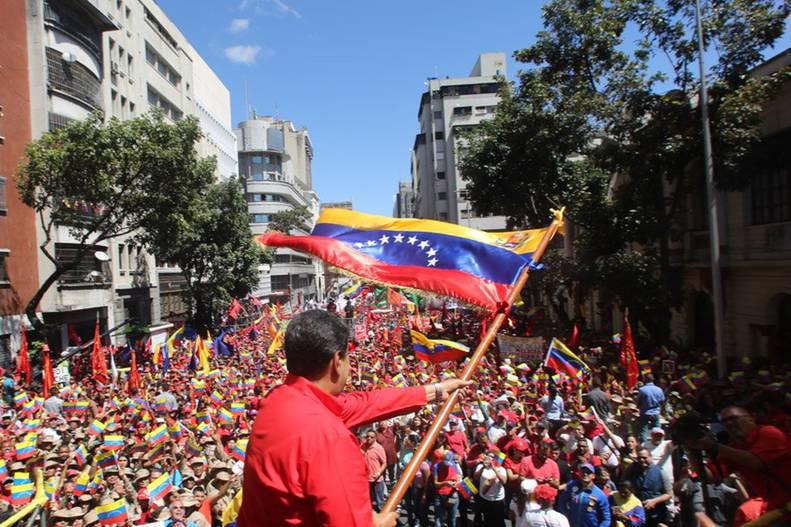 Zehntausende demonstrierten am Samstag in Caracas gegen Interventionismus und Krieg. Im Vordergrund Präsident Maduro mit der Landesflagge