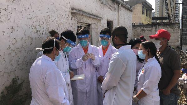 Ärzte aus China gehen mit Mitarbeitern eines Diagnosezentrums in Los Jardines de El Valle in Caracas von Haus zu Haus