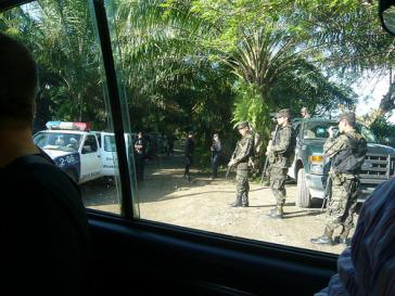 Blick aus dem Autofenster auf schwer bewaffnete Soldaten
