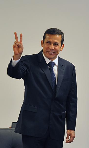 Ollanta Humala in schwarzem Anzug mach das Victory-Zeichen.