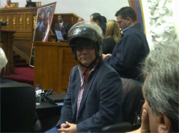 Der oppositionelle Abgeordnete Alfonso Marquina erschien bereits mit Motorrad-Helm zu Beginn der Sitzung. Der oppositionelle Abgeordnete Alfonso Marquina erschien bereits mit Motorrad-Helm zu Beginn der Sitzung.