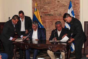 Tsipras und González (sitzend) bei der Unterzeichnung der Absichtserklärung