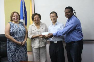 Botschafter Benjamin Ho (2. von rechts) überreicht Regierungsvertretern von Belize einen Scheck über 100.000 US-Dollar