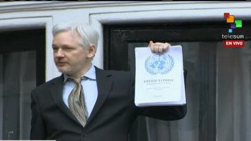 Assange zeigt den Beschluss der UN-Arbeitsgruppe auf dem Balkon der ecuadorianischen Botschaft in London
