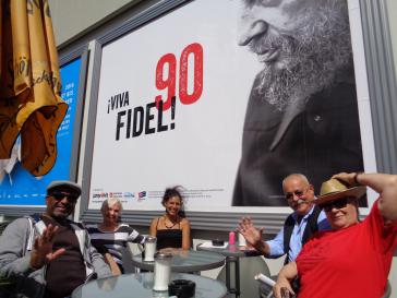 Aktivisten vor dem Geburtstags-Plakat für Fidel Castro in Berlin