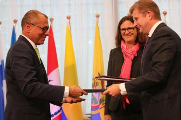 Ecuadors Vizepräsident Jorge Glas und die Vertreter der EU tauschen das unterzeichnete Abkommen aus