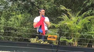 Leopoldo López zeigt sich den Medien und seinen Anhängern über der Mauer seines Anwesens in Venezuela, wo er unter Hausarrest steht Leopoldo López zeigt sich den Medien und seinen Anhängern über der Mauer seines Anwesens in Venezuela, wo er unter Hausarrest steht