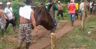 2017 begingen Militärs und Polizisten gemeinsam ein Massaker in der Pazifikregion von Kolumbien. Ein Ermordeter wird von Bauern abtransportiert