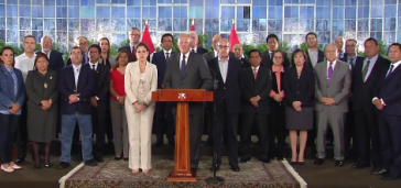 Der Präsident Perus zwischen weiteren Regierungsmitgliedern