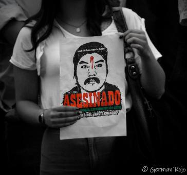 Eine Frau hält ein Poster, auf dem der ermordete Camilo Catrillanca zu sehen ist.