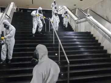 In Brasiliens Hauptstadt desinfizieren Soldaten den Busbahnhof. Währenddessen schüttelt Präsident Jair Bolsonaro woanders Hände. In Brasiliens Hauptstadt desinfizieren Soldaten den Busbahnhof. Währenddessen schüttelt Präsident Jair Bolsonaro woanders Hände.