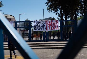 Ein Gitter an dem ein Transparent hängt. Dort steht auf Spanisch: "Drei Jahre nach der Revolte hat sich nichts geändert"