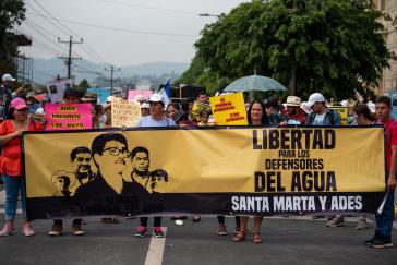 Die Gemeinde Santa Marta auf der 1.-Mai-Demonstration mit einem Transparent mit der Aufschrift "Freiheit für die Verteidiger des Wassers"