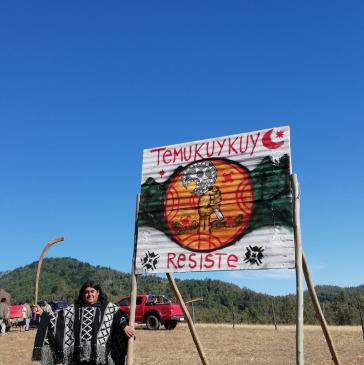 Jorge Huenchullán in traditioneller Kleidung vor einem Schild: "Temucuicui resiste". (Temucuicui leistet Widerstand) Jorge Huenchullán in traditioneller Kleidung vor einem Schild: "Temucuicui resiste". (Temucuicui leistet Widerstand)