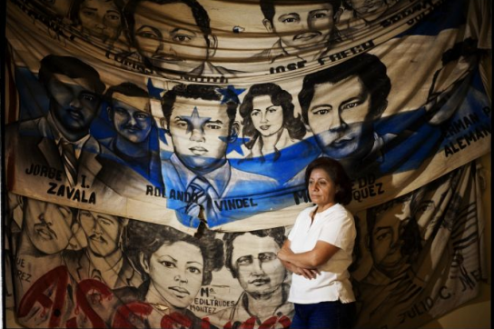 Bertha Oliva vor den Bildern von Opfern politischer Morde 