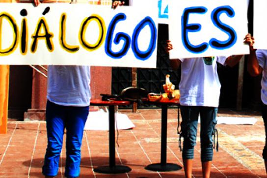 Menschen mit Schildern auf denen steht: "Der Dialog ist der Weg"