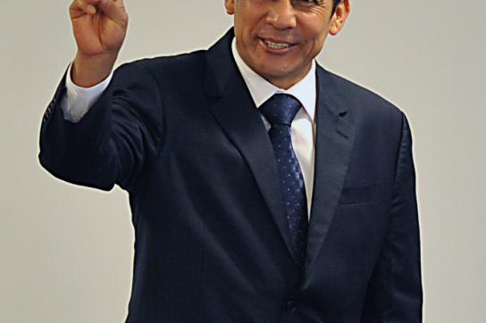 Ollanta Humala in schwarzem Anzug mach das Victory-Zeichen. 