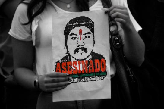 Eine Frau hält ein Poster, auf dem der ermordete Camilo Catrillanca zu sehen ist.